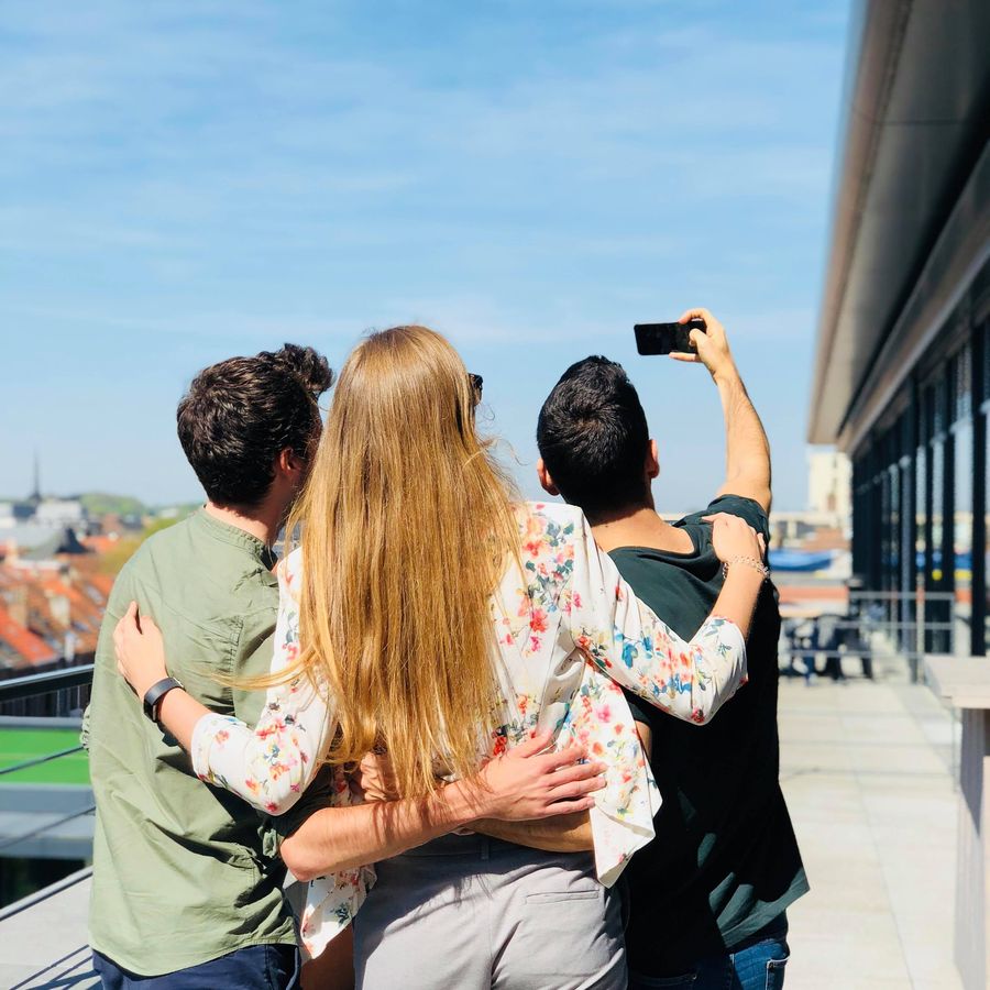 Teamleden maken samen een foto na een werkdag